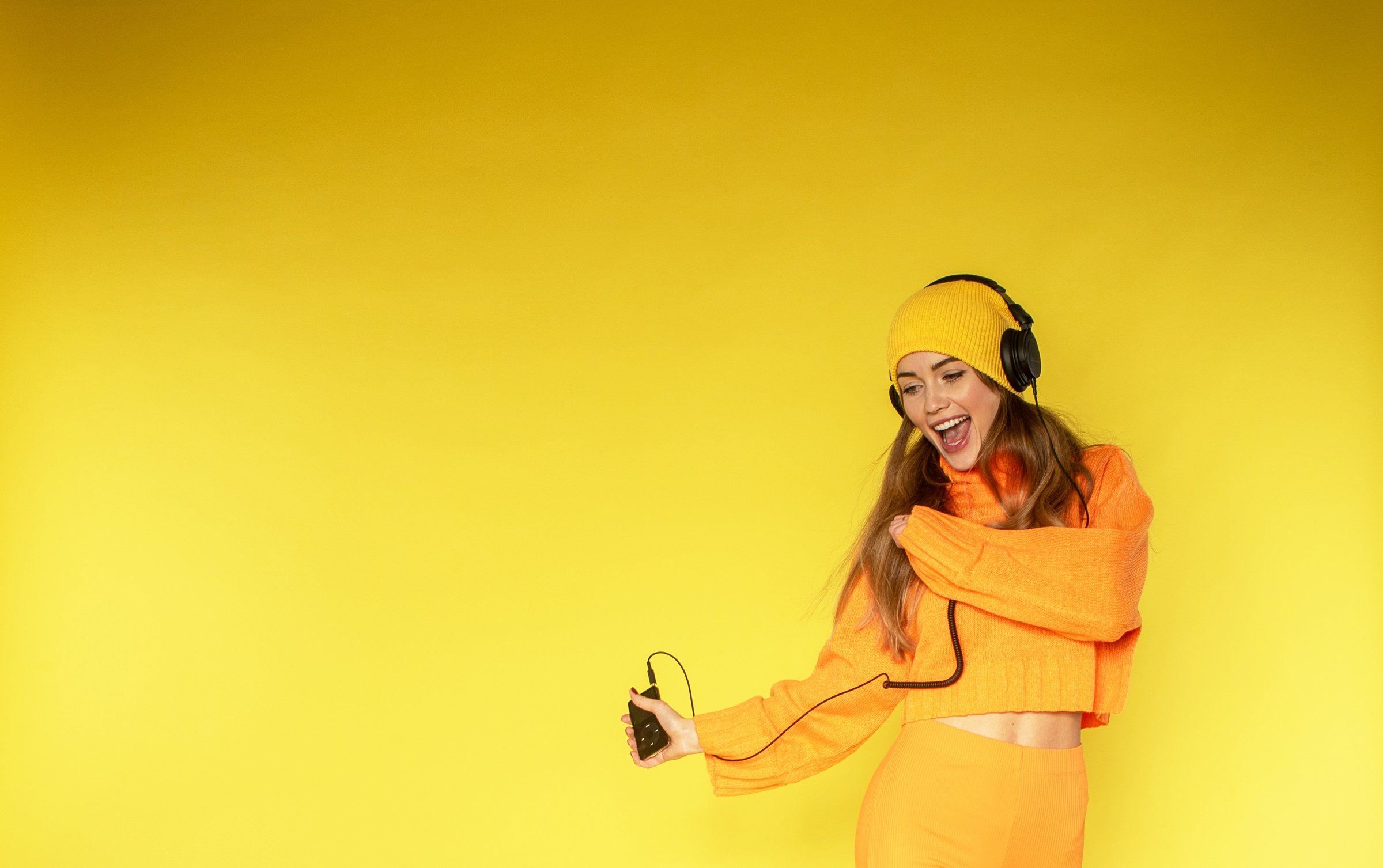 Woman Listening to Music on Yellow Background